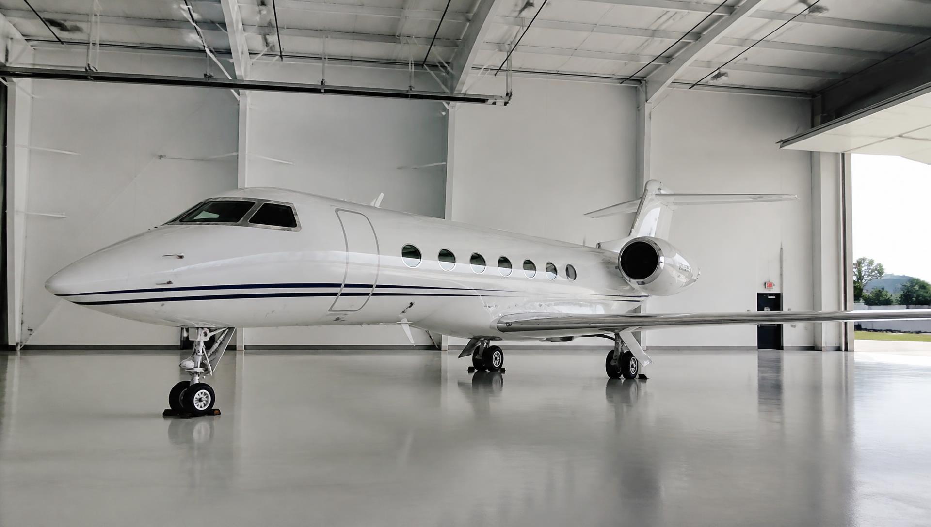 Freshly detailed white private jet with a mirror finish parked in a bright white hangar